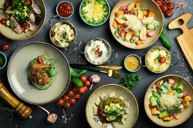 Yiyecekler. Tabakları masaya koyun. Karanlık bir taş arka planda. Metin için boş alan.