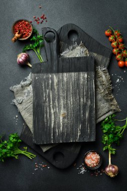 Menü sayfası için pankart. Sebzeli, baharatlı ve çatallı mutfak tahtası. Karanlık bir arka planda. Üst Manzara. Metin için boş alan.