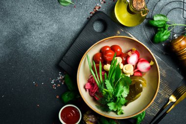 Sebze turşusu: lahana, salatalık, domates. Kapatın. Bir tabakta Siyah bir taşın arkasında.