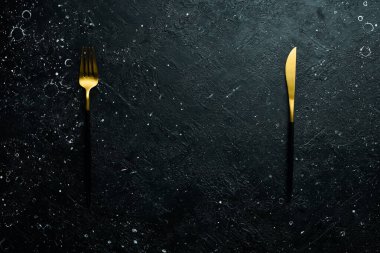 Masada çatal bıçak takımı var. Üst Manzara. Koyu bir arka planda.