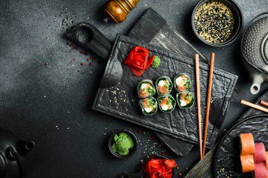 Somon, lahana yaprağı ve krem peynirli suşi ruloları. Wasabi sosu ve zencefil turşusuyla servis edilir. Geleneksel Japon yemekleri. Kapat..