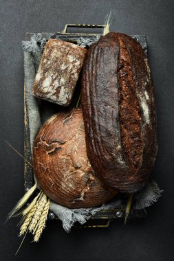 Ekmek ve hamur işleri. Siyah bir taş masanın üzerinde bir çeşit ekmek. Üst görünüm.