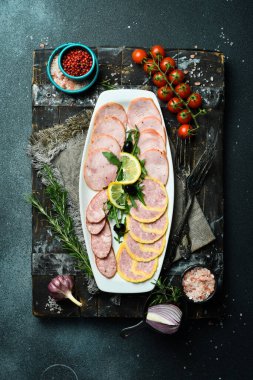 Tabakta farklı türde salam kesmek. Koyu bir arkaplanda.