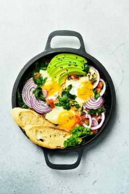 Geleneksel İsrail yemekleri Shakshuka. Domates soslu kızarmış yumurta. Gri beton masa. Üst Manzara. Kapat.