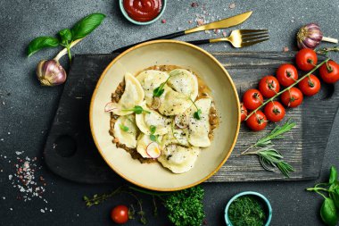 Patates ve mantar soslu börek. Siyah taştan bir arka planda. Bir tabakta, yakın plan..