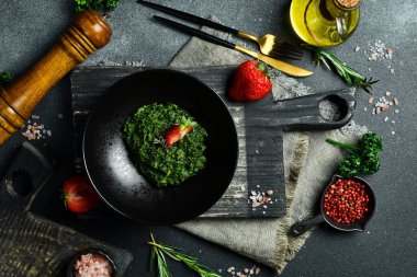 Ispanak tabakları. Kremalı sosta haşlanmış ıspanak. Tabakta. Sağlıklı yiyecekler. Karanlık bir taş arka planda.