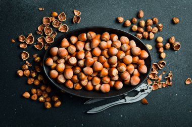 Fındık arka planı. Siyah oval kasede fındıklar. Sağlıklı beslenme. Kapat..