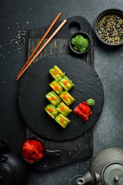 Siyah pirinçli suşi, siyah arka planda balık ve avokado. Suşi, nigiri, maki, zencefil turşusu, wasabi, soya sosu. Suşi masada hazır..