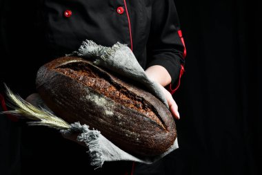 Kadınların elinde kokulu siyah oval ekmek. Ev yapımı çavdar ekmeği..