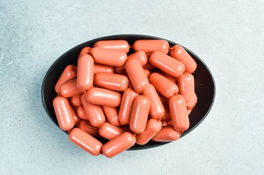 Bir kase pişmiş sosis, yemeye hazır. Üst Manzara. Gri beton arka planda. Kırsal biçim.