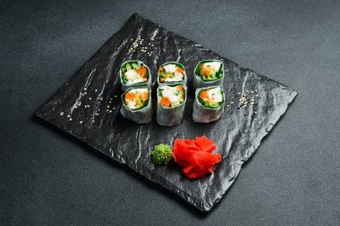 Geleneksel taze Japon suşisi rulo karides ve pirinç örtüsü. Wasabi sosu ve zencefil turşusuyla servis edilir. Kapat..