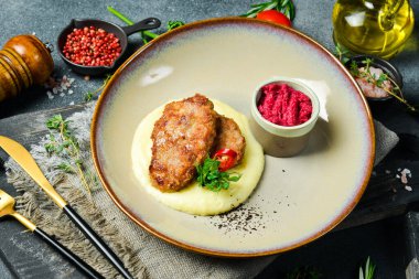 Domuz pirzolası ve pancar soslu patates püresi. Ev yapımı yemek. Karanlık bir taş arka planda.