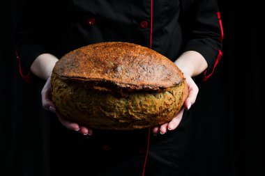 Fırıncının elinde taze ekşi ekmek. Üst görünüm.