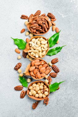 Işık taşı arka planında bir kasede bir takım fındık. Sağlıklı atıştırmalıklar. Çatlak.