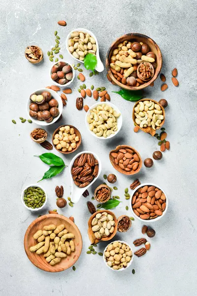 Fındık çeşitleri kaselerde. Taş zeminde çeşitli soyulan fındıklar. Üst görünüm.