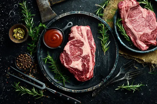 Taş tahtada taze çiğ ana Angus bifteği. Üst Manzara. Karanlık bir arka planda. - Et. Metin için boş alan.