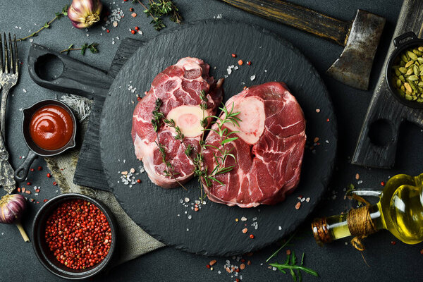 Two Raw Steak Ossobuco on a Slate Black Plate. Barbecue. On a black background. Free space for the recipe.