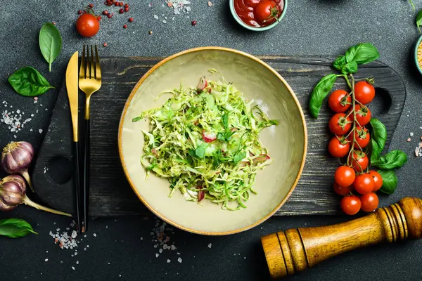 Sağlıklı yiyecekler. Taze lahana salatası, zeytinyağlı turp. Tabakta. Restoran servisi. Kapatın. Karanlık bir taş arka planda.
