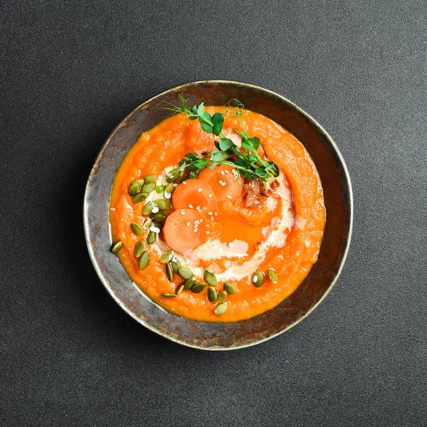 Kabak soslu ve kremalı kabak havucu kremalı çorba. Bir kasede. Sağlıklı gıda konsepti. Kapat..