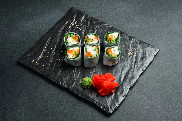 Geleneksel taze Japon suşisi rulo karides ve pirinç örtüsü. Wasabi sosu ve zencefil turşusuyla servis edilir. Kapat..