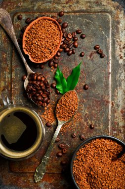 Kahve fonu. Hazır kahve ve kahve çekirdeği çeşitleri. Metalik paslı arka planda.