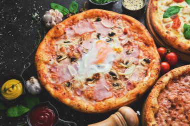 Mantarlı pizza, pastırma ve peynir. Siyah taşlı arka planda klasik pizza. Üst görünüm.