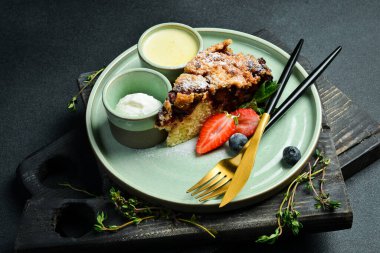 Pişirme. Dondurma ve dondurmalı bir dilim tatlı turta. Siyah taştan bir arka planda. Metin için boş alan.