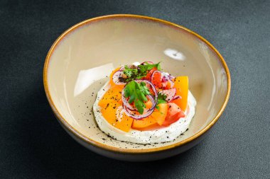 Renkli domates salatası, turp ve krem peynirli soğan. Tabakta. Siyah taştan bir arka planda. Yemek fotoğrafı..