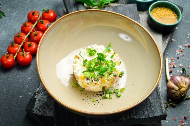 Yengeç çubuklu salata, mısır, soğan ve mayonez. Siyah taştan bir arka planda. Metin için boş alan.