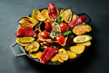 Saj - geleneksel Azerbaycan yemekleri. Metal bir tavada kuzu saj. Metin için boş alan. Karanlık bir arka planda.