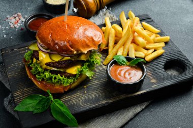 Ev yapımı hamburger ve ketçaplı patates kızartması. Fast food. Karanlık bir arkaplanda, yakın plan.