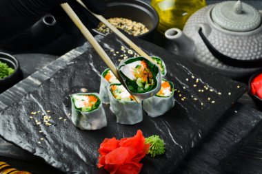 Geleneksel taze Japon suşisi rulo karides ve pirinç örtüsü. Wasabi sosu ve zencefil turşusuyla servis edilir. Kapat..