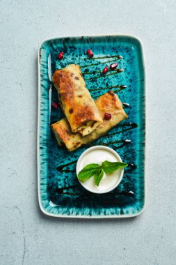 Et ve soslu gözleme. Bir tabakta Azerbaycan mutfağında. Metin için boş alan. Karanlık bir arka planda.