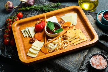 Peynir dilimi. Peynir yaylası. Koyu bir arkaplanda.