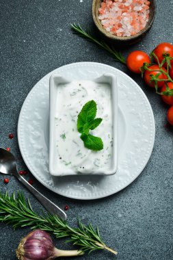 Beyaz kasede dereotlu ve sarımsaklı ekşi krema sosu. Geleneksel Tzatziki sosu, yoğurt veya ekşi kremayla yapılır. Metin için boş alan.