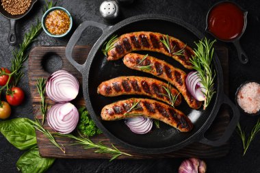 Izgarada, tavada pişmiş sulu sığır eti sosisi. Kapatın. Üst görünüm.