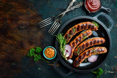 Izgarada, tavada pişmiş sulu sığır eti sosisi. Kapatın. Üst görünüm.