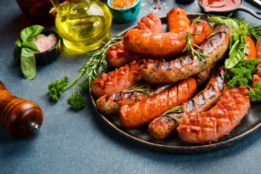 Büyük bir tabak domuz eti, sığır eti ve tavuk sosisi. Üst Manzara, kapat. Gri taştan bir arka planda.