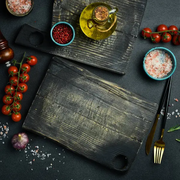 Siyah taş pişirme arka planı. Baharat ve sebze. Üst Manzara. Metnin için boş yer.