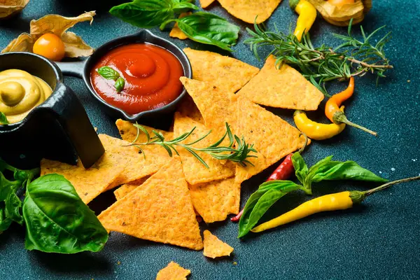 Baharatlı tortilla cipsi, domates sosu ve fesleğen. Mısır cipsi. Üst görünüm.