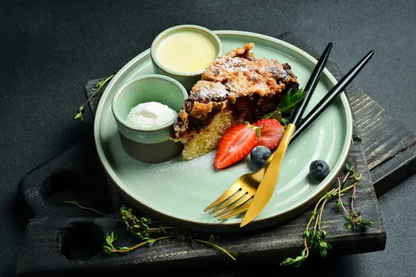 Pişirme. Dondurma ve dondurmalı bir dilim tatlı turta. Siyah taştan bir arka planda. Metin için boş alan.