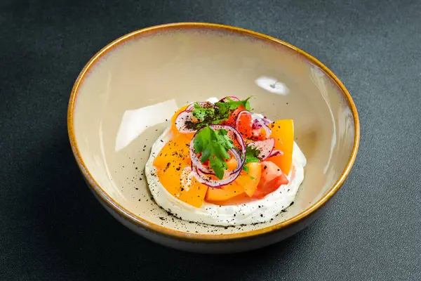 Renkli domates salatası, turp ve krem peynirli soğan. Tabakta. Siyah taştan bir arka planda. Yemek fotoğrafı..