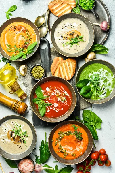 Diyet renkli sebze çorbaları: ıspanak, mantar, havuç ve balkabağı. Bir kasede. Sağlıklı beslenme kavramı. Üst görünüm.