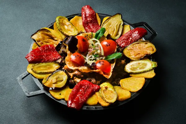 Saj - geleneksel Azerbaycan yemekleri. Metal bir tavada kuzu saj. Metin için boş alan. Karanlık bir arka planda.