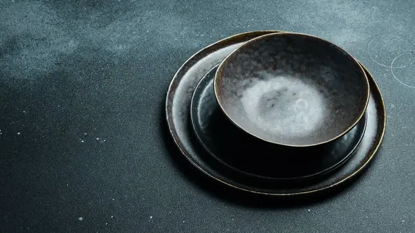 Koyu gri arka planda boş gri plaka (seramik). Metin için boş alan. Üst görünüm.