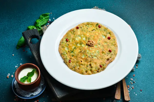Yeşil ve tuzlu yoğurtlu geleneksel Azerbaycan krepi. Metin için boş alan. Karanlık bir arka planda.