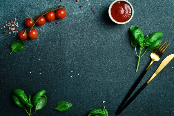 Mutfak afişi. Koyu taş bir masada çatal bıçak, sebze ve baharatlar. Metin için boş alan.