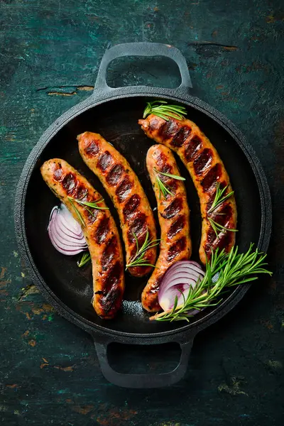 Izgarada, tavada pişmiş sulu sığır eti sosisi. Kapatın. Üst görünüm.