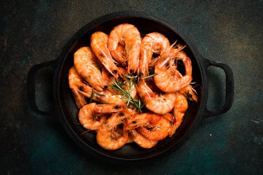 Dökme demir tavada kavrulmuş baharatlı karides. Deniz ürünleri pişirme geçmişi.
