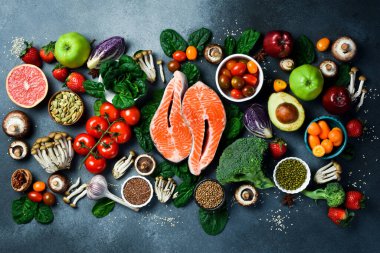 Sağlıklı yiyecekler temiz yemek seçimi: taze meyve, böğürtlen, süper yiyecek, fındık, balık ve mantar. Gri beton arka planda. Üst görünüm.